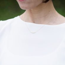 デコルテを彩るグラデーションのゆるやかな一文字型ネックレス